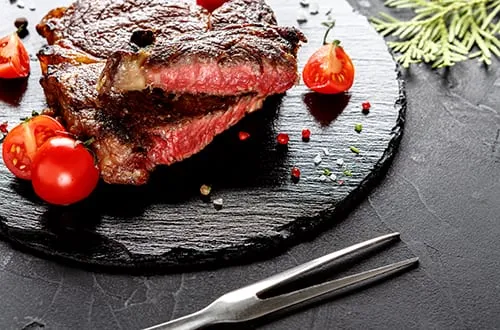 Rare rib eye steak on dark plate closeup PP9SRD4