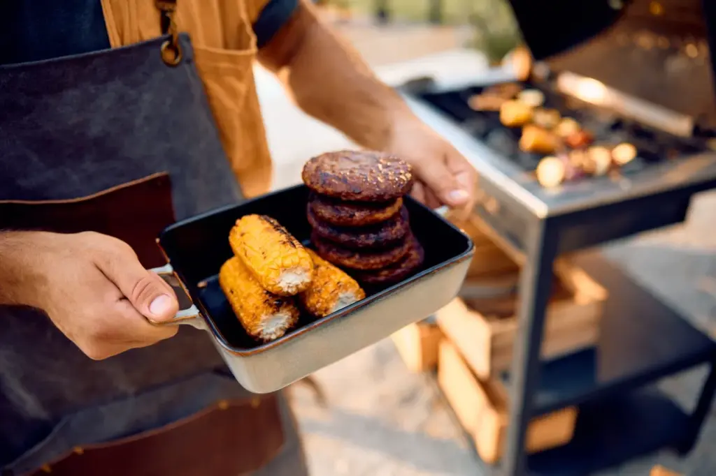 Close up of man with grilled corn and hamburgers 2026 01 06 10 30 16 utc groot